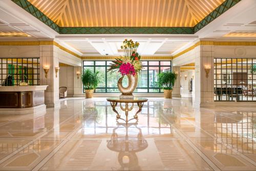 a lobby with a vase with flowers on a table at Xijiao State Guest Hotel in Shanghai