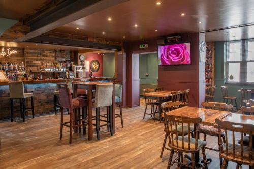 eine Bar in einem Restaurant mit Holztischen und -stühlen in der Unterkunft The Riverside in Spalding