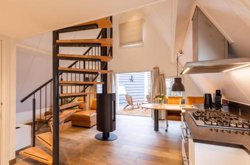a kitchen with a spiral staircase and a living room at Hof van Salland Hellendoorn in Hellendoorn