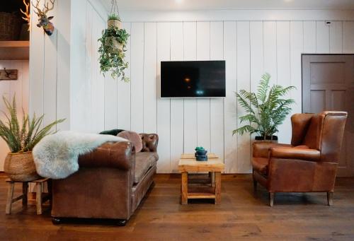 a living room with two couches and a tv at Forest Hotel in Den Helder