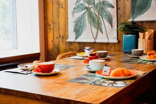 a wooden table with cups and plates of food on it at Forest Hotel in Den Helder