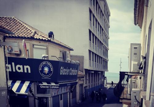 a group of buildings on a street next to the ocean at COTE PLAGE HYPER CENTRE - Bord de mer in Le Grau-du-Roi