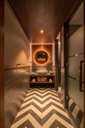 a bathroom with a sink on a checkered floor at Fusion Original Saigon Centre in Ho Chi Minh City