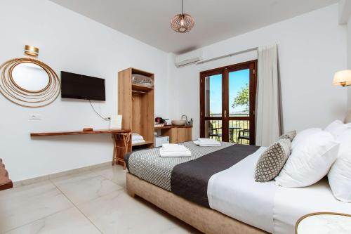 um quarto de hotel com uma cama e uma televisão em Deluxe Suites em Chania Town