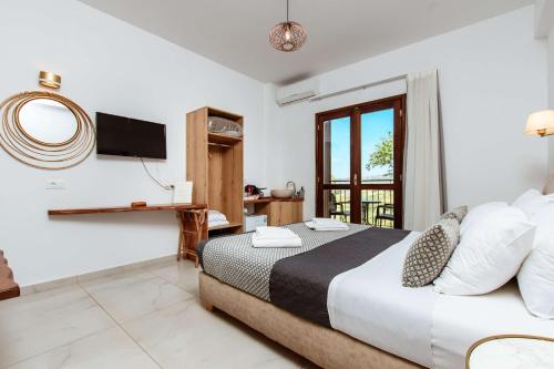 une chambre d'hôtel avec un lit et une télévision dans l'établissement Deluxe Suites, à La Canée