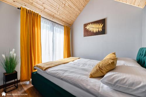 a bedroom with a bed and a large window at Green Fields village in Sosnówka