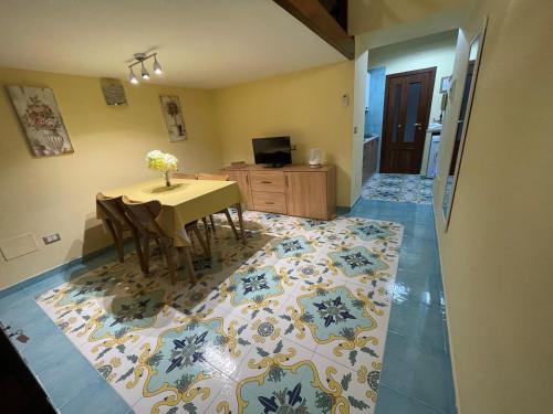 a dining room with a table and chairs on a rug at Sorrento City Center Atmosphere in Sorrento