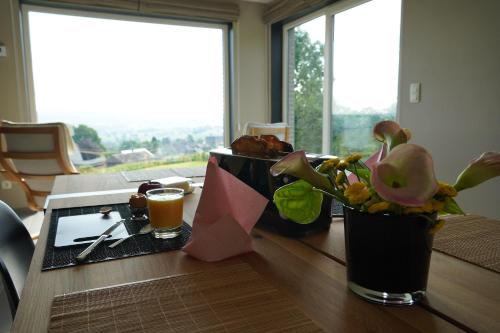 a table with a plate of food and a glass of beer at "Petite perle en Haute Ardenne" avec vue sur la vallée, cabine infra-rouge et bain balnéo in Lierneux