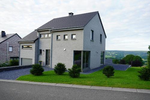 a house with a black roof on a green lawn at "Petite perle en Haute Ardenne" avec vue sur la vallée, cabine infra-rouge et bain balnéo in Lierneux
