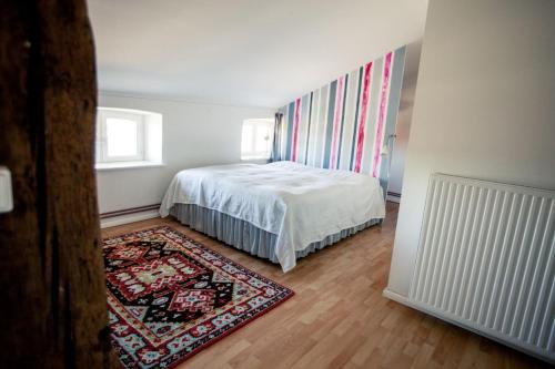a bedroom with a white bed and a rug at Gut Pohnstorf in Alt Sührkow