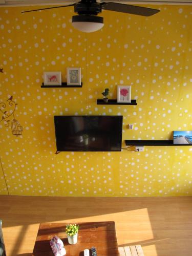 a living room with a yellow wall with white polka dots at Corner Inn九份住宿I 小角落民宿I 機車租借I日夜間導覽 in Jiufen