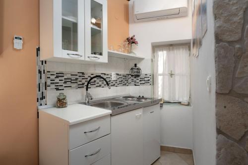 a kitchen with white cabinets and a sink at Casa Albina in Rovinj