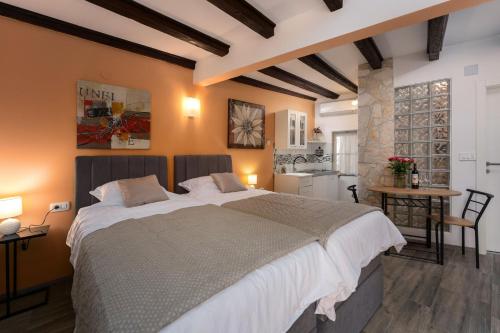a bedroom with a large bed and a kitchen at Casa Albina in Rovinj