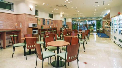 a dining room with tables and chairs in a restaurant at Toyoko Inn Kawasaki Ekimae Shiyakusho-dori in Kawasaki