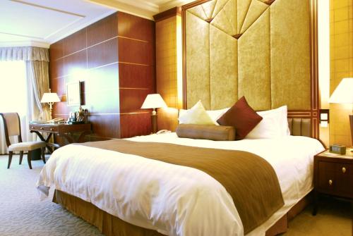 a hotel room with a large bed and a desk at Xijiao State Guest Hotel in Shanghai