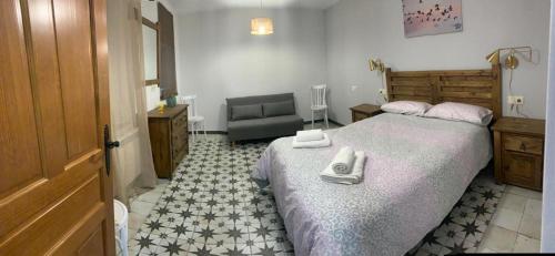 Un dormitorio con una cama con un par de zapatos encima. en Casa de los Maestros, en Rágama