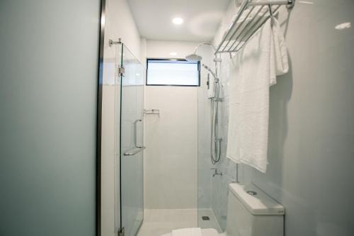 y baño con ducha de cristal y aseo. en De Thaphae Chiangmai en Chiang Mai