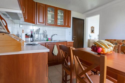 a kitchen with a wooden table with a bowl of fruit on it at Pelion house with stunning view to relax in Vyzitsa