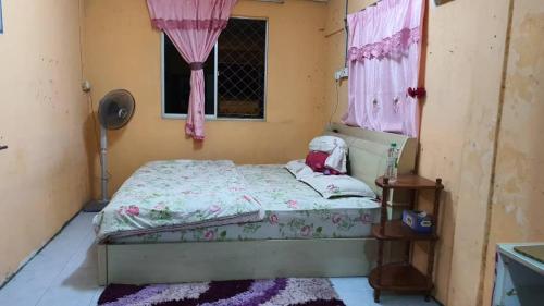 um pequeno quarto com uma cama e uma janela em HOMESTAY AINNUR SEMARAK em Tawau