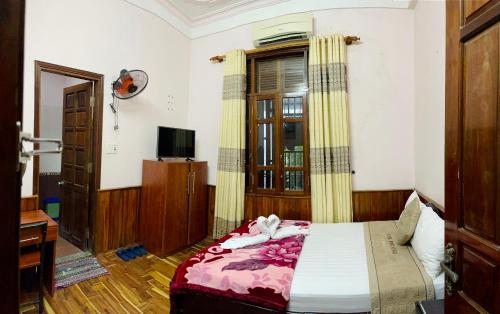 a bedroom with a bed and a window and a television at Nam Phương Riverside Villa in Hue