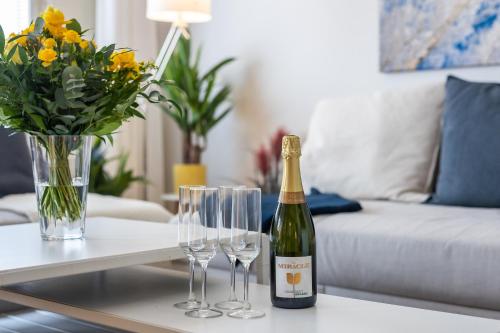 a bottle of champagne and wine glasses on a table at City Holiday Apartments 1 in Rovaniemi
