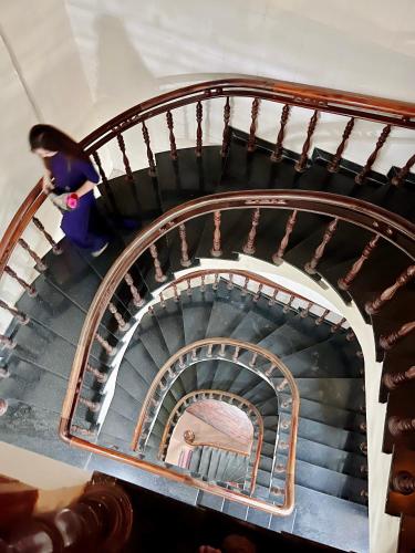 a spiral staircase with a person walking down it at Nam Phương Riverside Villa in Hue