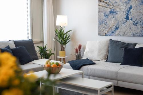 una sala de estar con 2 sofás y un bol de fruta en City Holiday Apartments 1 en Rovaniemi