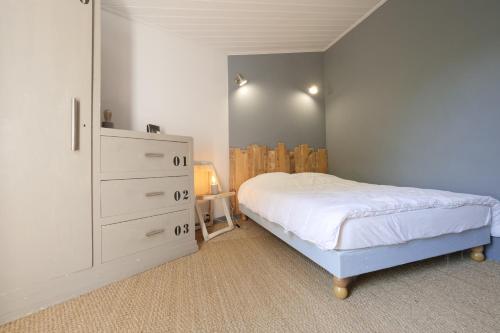 een slaapkamer met een wit bed en een dressoir bij Ensemble, dans une maison avec jardin près de la mer in Brétignolles-sur-Mer