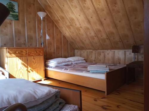 een slaapkamer met een groot bed in een houten kamer bij Domek DANKA - do 4 osob- lasy Natura 2000 - do jeziora 300 m in Olpuch