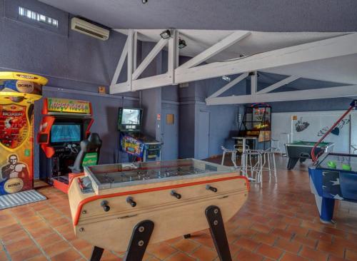 a room with a pool table and arcade games at Bungalow de luxe de 60m2 dans camping 5 étoiles in Puget-sur Argens