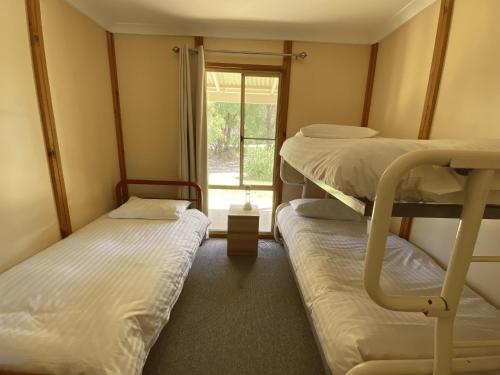 a room with three bunk beds and a window at Ocean View walk to the beach & Surfers Point - Margaret River Properties in Prevelly