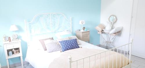 - une chambre bleue et blanche avec un lit et un lavabo dans l'établissement Chez Stephane et Sylvie, au Mans