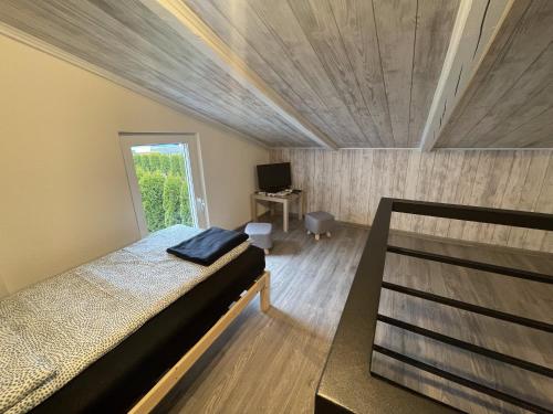 um pequeno quarto com uma cama e uma televisão em DOMEK FANTAZJA em Spytkowice