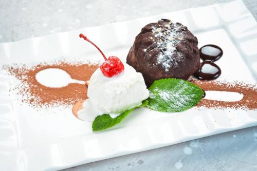 a chocolate dessert with a cherry on a white plate at Курортний Готель Золота Корона in Truskavets