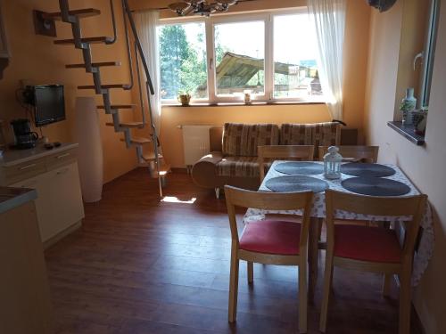 een woonkamer met een tafel en stoelen en een bank bij Domek DANKA - do 4 osob- lasy Natura 2000 - do jeziora 300 m in Olpuch