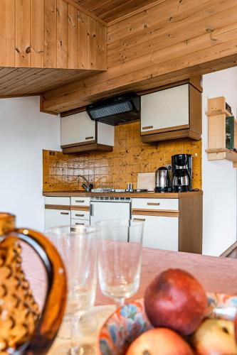 a kitchen with a table with apples and glasses on it at Residence Greymold in Rifiano