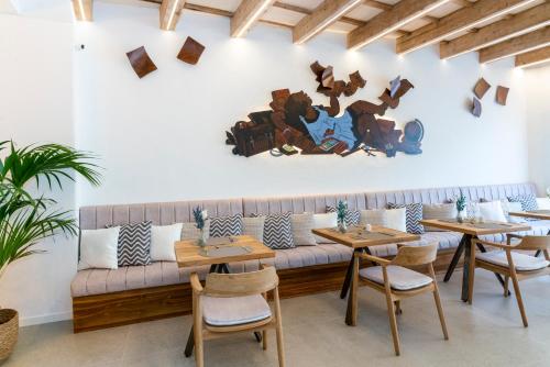 a restaurant with wooden tables and a couch at Hotel S'Antiga Adults Only in Es Mercadal