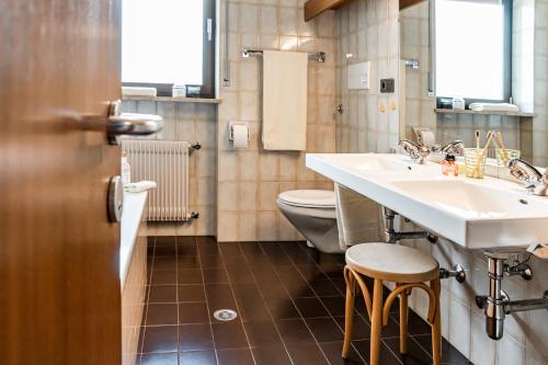 a bathroom with two sinks and a toilet at Residence Greymold in Rifiano