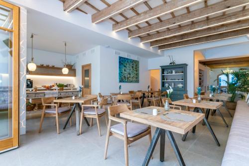 a dining room with wooden tables and chairs at Hotel S'Antiga Adults Only in Es Mercadal