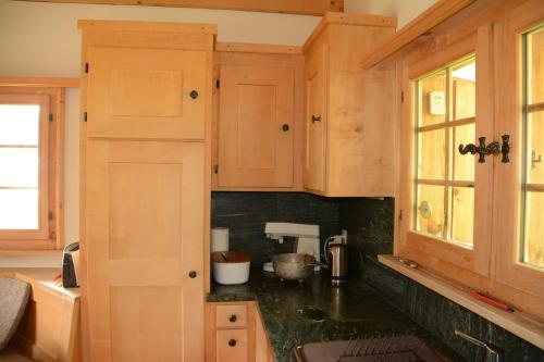 a kitchen with wooden cabinets and a black counter top at Vesmira in Sedrun