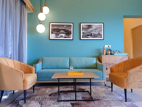 a living room with a blue couch and two chairs at Rakkh Resort, a member of Radisson Individuals Retreats in Pālampur