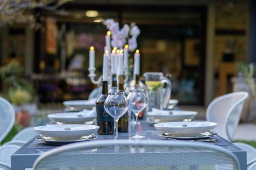スタラ・ザゴラにあるVILLA YANA Hotel Winery&Spaのキャンドルとワイングラスが置かれたテーブル