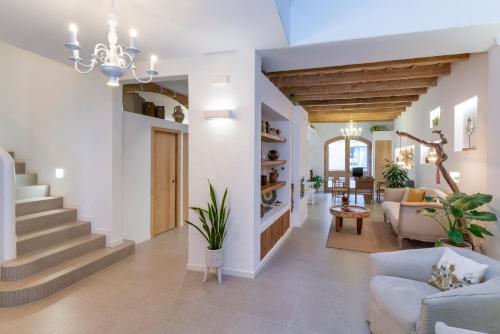 a living room with white walls and a staircase at Hotel S'Antiga Adults Only in Es Mercadal