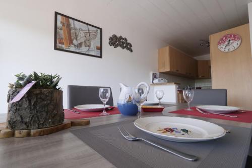 a dining room table with a plate and wine glasses at Un appartement sur la marina de St-Gilles in Saint-Gilles-Croix-de-Vie