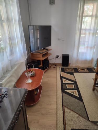uma sala de estar com uma televisão de ecrã plano e uma mesa em Poiana dintre Brazi Chalet, Bucegi Panorama em Sinaia