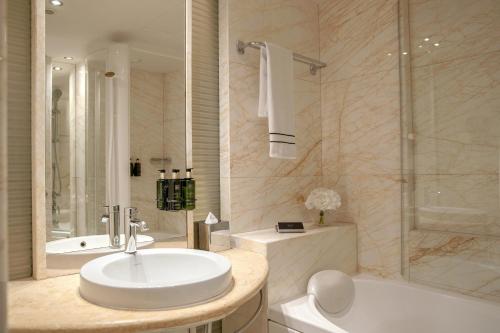 a bathroom with a sink and a tub and a toilet at Melia Athens in Athens