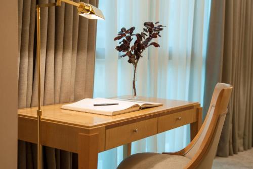 a desk with a lamp and a plant on it at Melia Athens in Athens