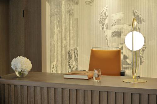 a desk with a book and a lamp and a glass at Melia Athens in Athens