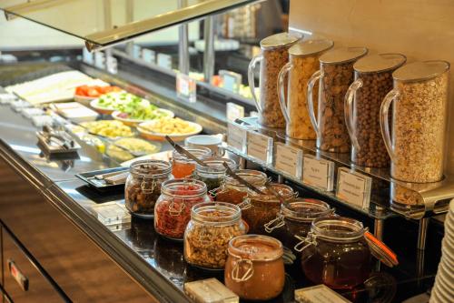 a buffet line with jars of food and other foods at Melia Athens in Athens