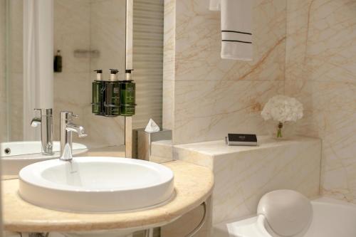 a bathroom with a sink and a toilet and a tub at Melia Athens in Athens